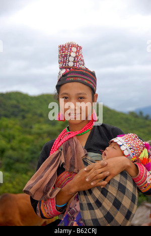 Junge Frau des Stammes Akha Pala in traditioneller Tracht mit ihrem Baby, Ban Pakha, Provinz Phongsali, Laos, Südostasien Stockfoto