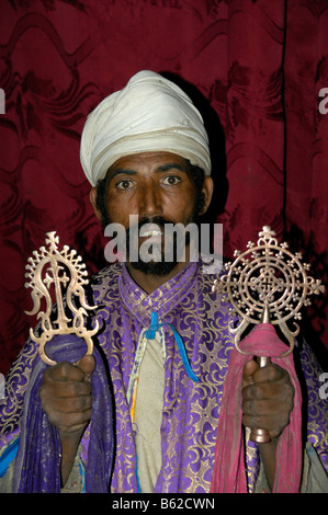 Priester mit Turban, halten zwei kunstvolle Kerzen, monolithische Kirche, Lalibela, Äthiopien, Afrika Stockfoto