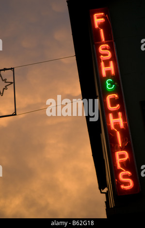 Seltsames Licht auf Mammatus Mammatocumulus Wolken am Himmel bei Sonnenuntergang mit einem beleuchteten Leuchtreklame für Fish &amp; Chips-Shop UK Stockfoto