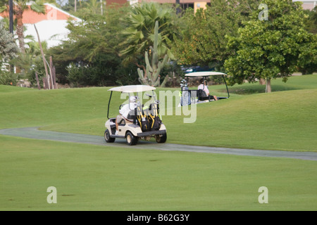 Golfer fahren Golf-Carts entlang der Fahrrinne im "The Links at Divi Aruba" Resort auf der Karibik-Insel Aruba Stockfoto