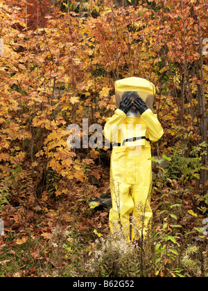 43 Jahre alten asiatischen Mann in einem Hazmat-Anzug und Gasmaske im Freien mit den Herbstfarben und Laub Stockfoto