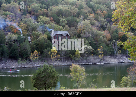 Rustikale Blockhütten in das Herbstlaub von den Hügeln von Missouri mit dem Kanu im See unten Stockfoto