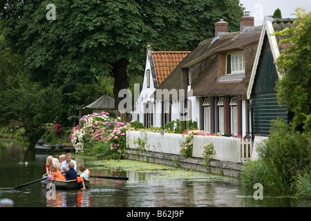 Niederlande Noord Holland Graveland Mann und Kinder im Ruderboot vor alten Bauernhof Stockfoto