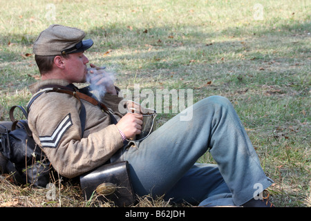 Soldat der Konföderierten Bürgerkrieg in der Pause essen und mit einer Zigarre während einer Civil War Reenactment im alten Wade House Stockfoto