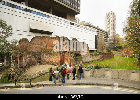 Walking Tour Gruppe Besuch Mauer der London Wall im Barbican, London England UK, Reste der alten römischen Verteidigung Londinium Stockfoto