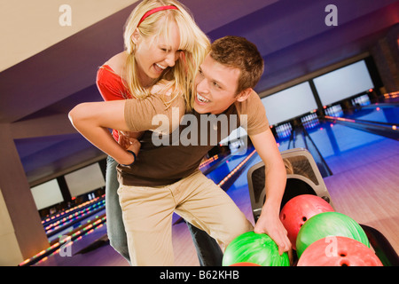 Junge Frau, die einen jungen Mann Huckepack Stockfoto