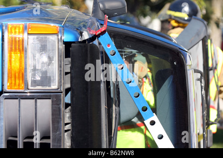 Feuerwehrleute arbeiten auf ein Auto, das von mit Haltestangen gerollt hat zu stabilisieren Stockfoto