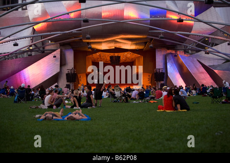 Touristen sitzen vor einem Auditorium, Jay Pritzker Pavillion, Millennium Park, Chicago, Illinois, USA Stockfoto