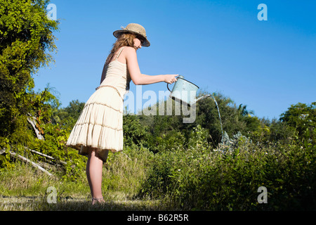 Seitenansicht eines Mädchens Bewässerung von Pflanzen Stockfoto