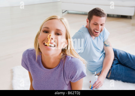 Paar auf Teppich sitzen und Lächeln Stockfoto