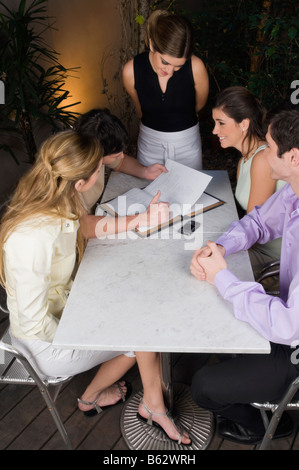 Vogelperspektive Blick auf zwei Paare, die auf einer Speisekarte in einem restaurant Stockfoto