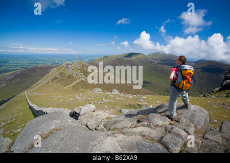 Walker auf die Mourne Mountains vom Gipfel des Slieve Bearnagh, County Down, Nordirland, Großbritannien. Stockfoto