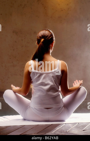 Rückansicht einer jungen Frau am Pool zu meditieren Stockfoto