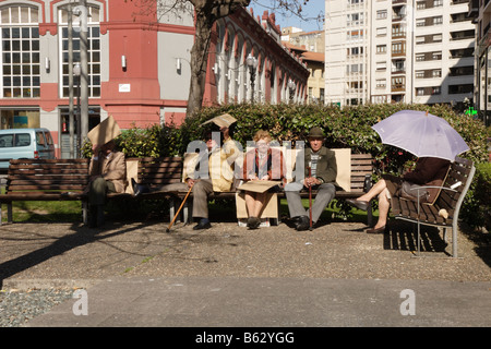 Eine Gruppe von Rentnern, die sitzen auf Bänken in Gijon Spanien Stockfoto