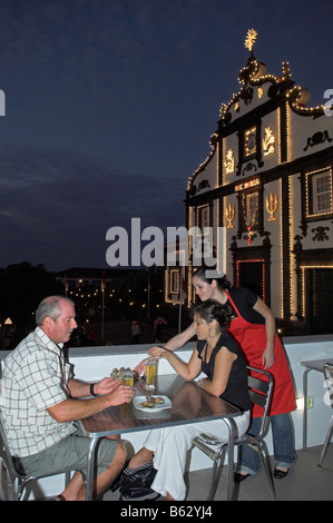 Abendessen auf Dach Terrasse im Dorf von Maia neben lokalen Kirche beleuchtet für religiöses Fest Stockfoto