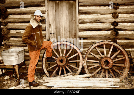 Porträt eines Mitte erwachsenen Mannes Stand in der Nähe Wagenräder, Old Trail Town, Cody, Wyoming, USA Stockfoto