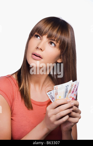 Nahaufnahme einer jungen Frau, die mit Euro-Banknoten Stockfoto