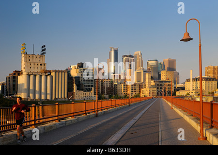 Am frühen Morgen Jogger und Minneapolis Hochhaus Turm Skyline aus der Stein-Bogen-Brücke bei Sonnenaufgang Stockfoto