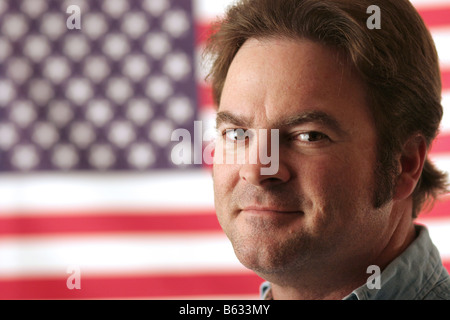 Ein gut aussehender Mann lächelnd vor einer amerikanischen Flagge Stockfoto