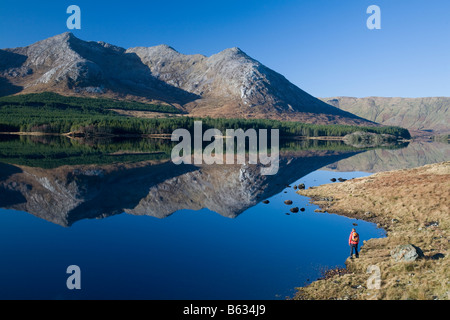 Walker unter der Twelve Bens Berge, am Ufer des Lough Inagh, Connemara, County Galway, Irland. Stockfoto