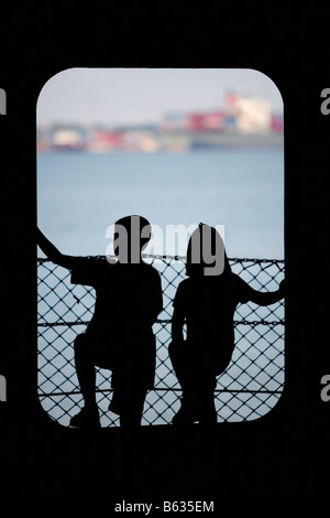 Silhouette eines jungen mit seiner Schwester stehen an einer Tür, Hudson River, New York City, New York State, USA Stockfoto