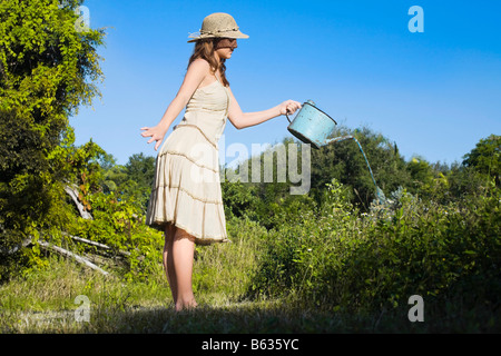 Seitenansicht eines Mädchens Bewässerung von Pflanzen Stockfoto