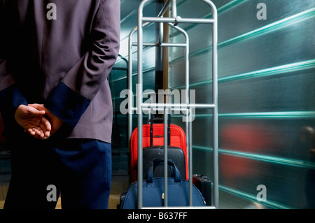 Rückansicht der Kellner Stand in der Nähe einen Gepäckträger Stockfoto
