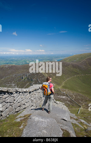 Walker neben der Mourne Wall an den Hängen des Slieve Bearnagh, Mourne Mountains, County Down, Nordirland, Großbritannien. Stockfoto