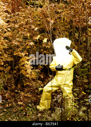 43 Jahre alten asiatischen Mann in einem Hazmat-Anzug und Gasmaske im Freien mit den Herbstfarben und Laub Stockfoto