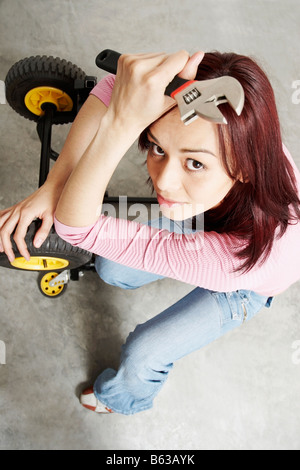 Erhöhte Ansicht einer junge Frau mit einem Schraubenschlüssel Stockfoto