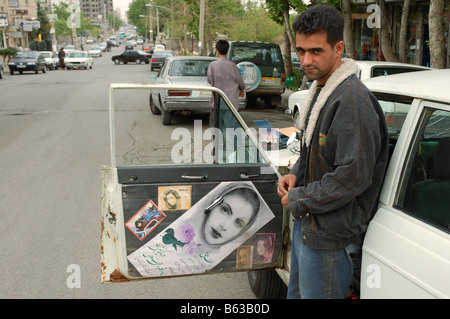 Taxifahrer posiert neben seinem Hillman Hunter in Teheran Stockfoto