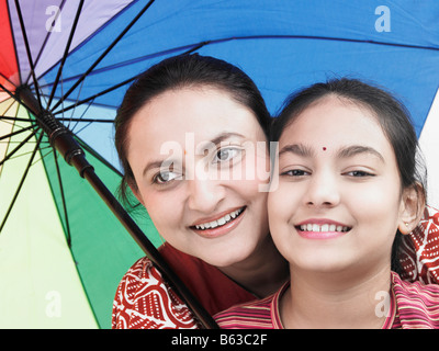 Mutter und Tochter mit einem mit Regenbogen Regenschirm Stockfoto