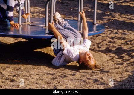 Junge spielt auf Karussell auf Stadt-Park-Spielplatz Stockfoto