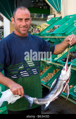 Ein Fischhändler mit einem jungen Schwertfisch auf einen Fisch stand auf dem Markt unter freiem Himmel in Rabat Gozo Malta Stockfoto