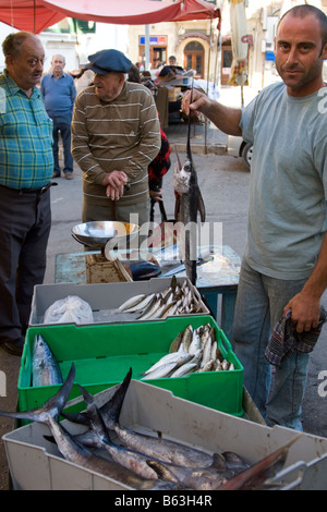 Ein Fischhändler mit einem jungen Schwertfisch auf einen Fisch stand auf dem Markt unter freiem Himmel in Rabat Gozo Malta Stockfoto