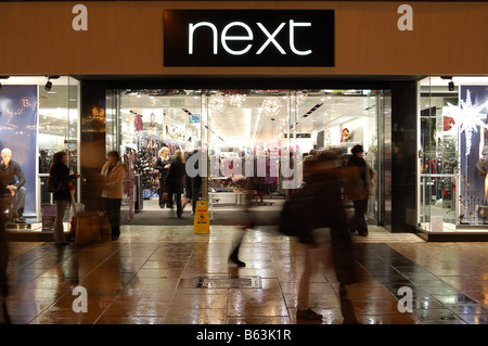 Shopper in und aus der nächsten hetzen speichern Queen St Cardiff Stockfoto