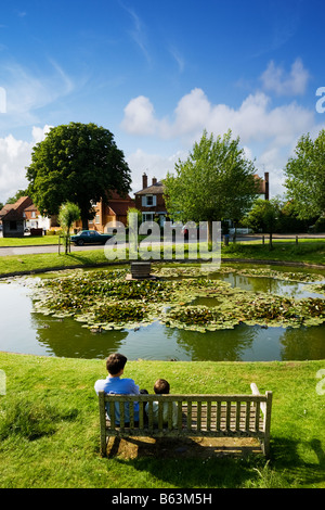Ententeich, UK - zwei Kinder beobachten die Enten in Wisborough Green Village, West Sussex, England Stockfoto