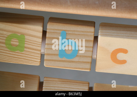 Gemalte Buchstaben auf ein hölzernes Spielzeug Alphabet frame Stockfoto