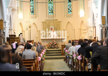 Ein Priester führt eine Trauung in einer katholischen Kirche Stockfoto