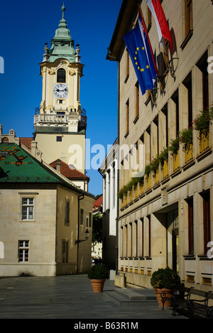 Quadratisch und clock Tower von Bratislava Altstädter Rathaus an einem sonnigen Tag vor blauem Himmel mit europäischen und Slowakische Fahnen. Stockfoto