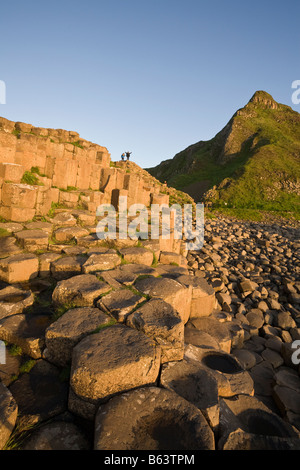 Hochstimmung: Tourist streckt ihre Hände als sie einen Höhepunkt auf der sechseckigen Säulen des Causeway erreicht Stockfoto