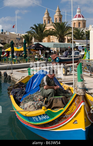 Fischer in seiner traditionellen Fischerboot in Marsaxlokk, Malta. Stockfoto