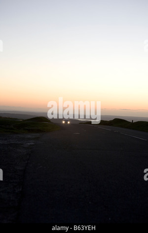 Auto auf der Straße bei Nacht. Dartmoor Nationalpark Sonnenuntergang Winter, Devon, England, UK Stockfoto