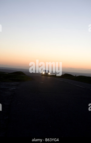 Auto auf der Straße bei Nacht. Dartmoor Nationalpark Sonnenuntergang Winter, Devon, England, UK Stockfoto
