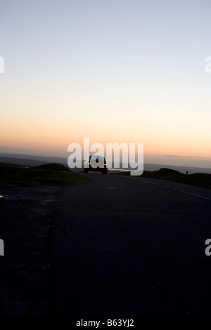 Auto auf der Straße bei Nacht. Dartmoor Nationalpark Sonnenuntergang Winter, Devon, England, UK Stockfoto