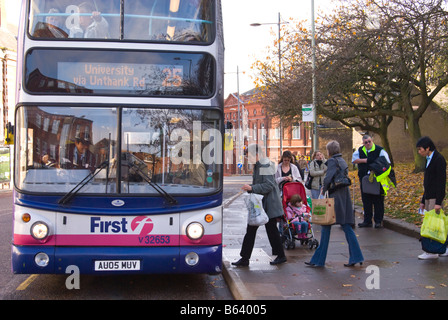 Menschen Queing up in Que, ein Bus an der Bushaltestelle der Stadt im Vereinigten Königreich Stockfoto