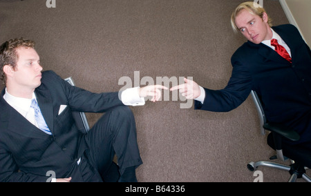 Zwei Geschäftsleute in Anzügen sitzen im Büro wenden sich Finger berühren Stockfoto