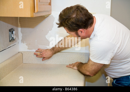 Auftragnehmer eine laminate Arbeitsplatte Installation und setzen in die Aufkantung Stockfoto