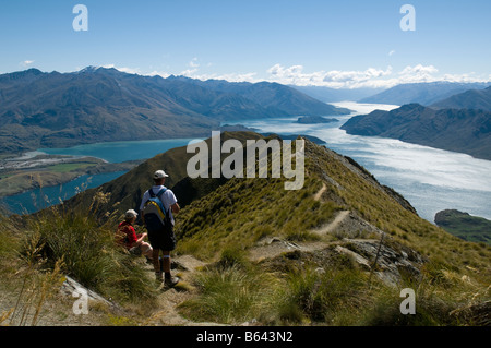 Zwei Wanderer auf dem Roys Peak mit Blick auf den Lake Wanaka, Südinsel, Neuseeland Stockfoto