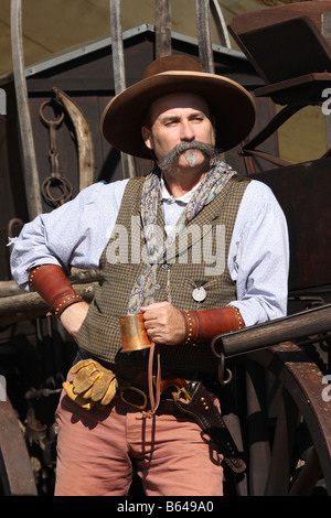 Ein Cowboy stützte sich auf einen Chuckwagon mit seiner Metallschale Stockfoto